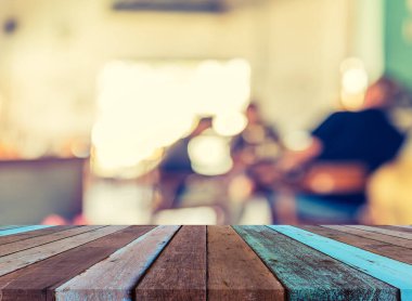 Ahşap masa ve kahve dükkanı arkaplanı Bokeh ile bulanık görünüm.