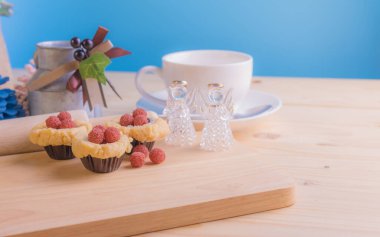 Ahşap masanın üzerinde arkaplanda çeşitli dekorasyonlarla yabanmersini Crumb Cake resmi.