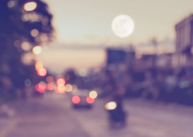 Arka plan kullanımı için akşam vakti yolda bulanık bir araba görüntüsü. (Klasik ton))