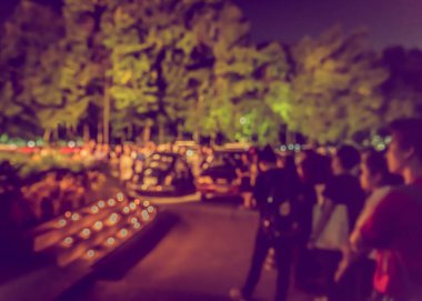 Bulanık insanlar sokakta mum ışığında kurbanlar için dua ediyorlar.