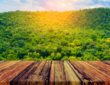 Ahşap masa ve arka planda yeşil dağın bulanık görüntüsü .