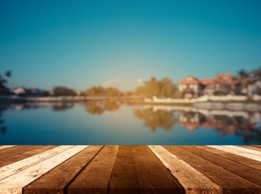 Ahşap iskele ya da eski ahşap masa. Arka planda gölün ve günbatımı görüntüsü bulanık.