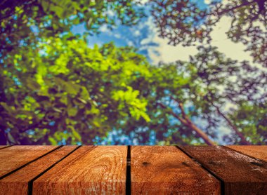 Arkaplan kullanımı için ahşap tablo ve yeşil ağaç bokeh 'in soyut bulanık resmi .