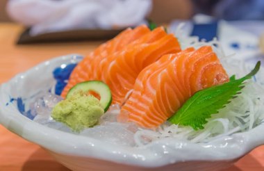 Tabakta buzda dilimlenmiş çiğ ve taze somon resmi..