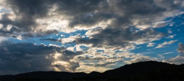 Arkaplanda dağ ve günbatımı görüntüsü.