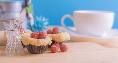 Ahşap masanın üzerinde arkaplanda çeşitli dekorasyonlarla yabanmersini Crumb Cake resmi.