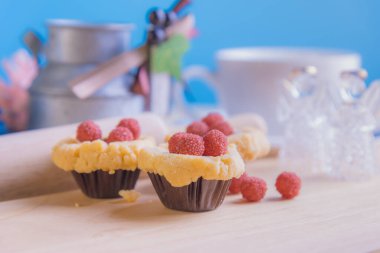 Ahşap masanın üzerinde arkaplanda çeşitli dekorasyonlarla yabanmersini Crumb Cake resmi.