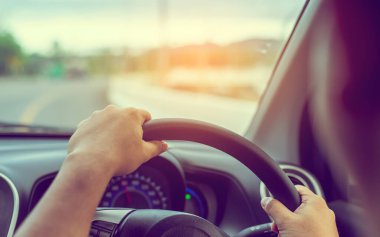 Arka plan kullanımı için gündüz vakti araba kullanan insanların klasik ton görüntüsü. (içeriden fotoğraf çek sürücü eline odaklan)