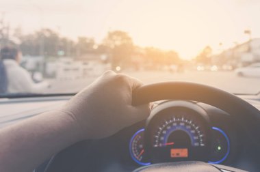 Arka plan kullanımı için gündüz vakti araba kullanan insanların klasik ton görüntüsü. (içeriden fotoğraf çek sürücü eline odaklan)