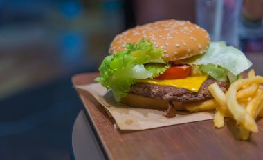 Masada taze sebzeli etli hamburger resmi.