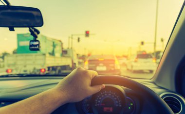 Arka plan kullanımı için gündüz vakti araba kullanan insanların klasik ton görüntüsü. (içeriden fotoğraf çek sürücü eline odaklan)