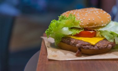 Masada taze sebzeli etli hamburger resmi.