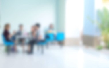 Arka planda oturma odasında oturan insanların bulanık görüntüsü.