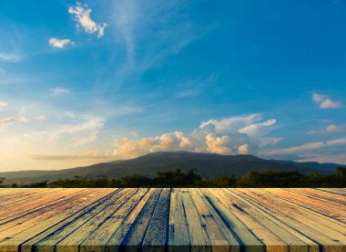 Ahşap masa ve arka planda yeşil dağın bulanık görüntüsü .