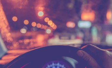 Arka plan kullanımı için gece vakti araba kullanan insanların klasik ton bulanık görüntüsü. (içeriden fotoğraf çek)