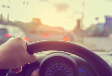 Arka plan kullanımı için gündüz vakti araba kullanan insanların klasik ton görüntüsü. (içeriden fotoğraf çek sürücü eline odaklan)