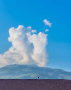 Minyatür bebek fikri fotoğrafçı görüntüsü. Güzel dağ ve mavi gökyüzü. Gün içinde arka planda..