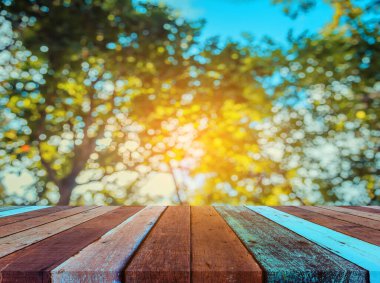 Arkaplan kullanımı için ahşap tablo ve yeşil ağaç bokeh 'in soyut bulanık resmi .