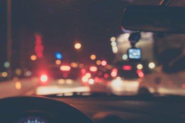 Arka plan kullanımı için gece vakti araba kullanan insanların klasik ton bulanık görüntüsü. (içeriden fotoğraf çek)