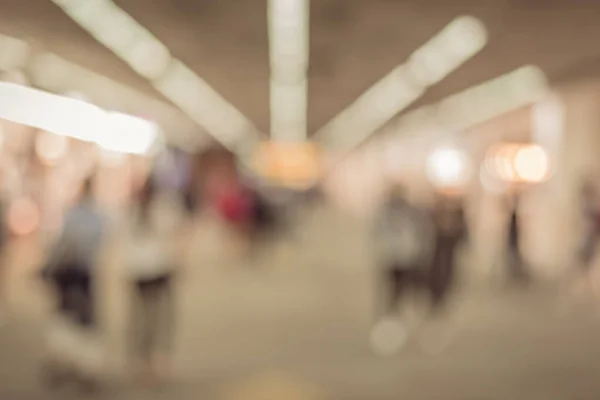 vintage tone blurred image of people walking at hallway in airport for background usage .