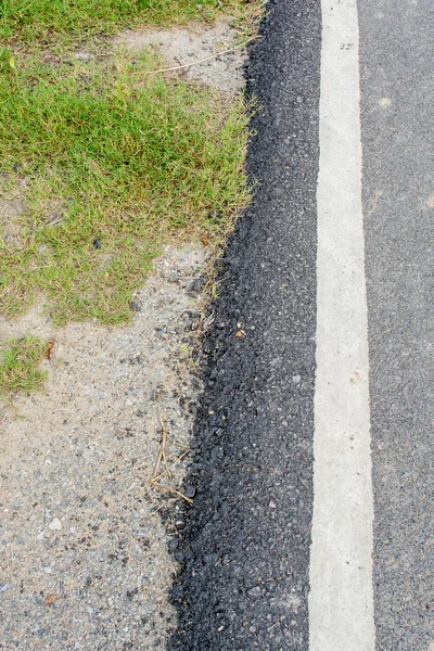 道路のアスファルトの質感を草や岩で表現しました — ストック写真