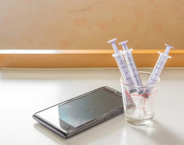 Syringe And smart phone — Stock Photo, Image