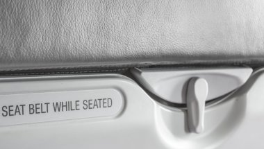 fasten emniyet kemeri oturmuş işaret ederken görüntüsünü.