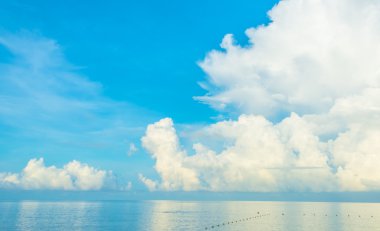 mavi deniz ve bulutlu mavi gökyüzü ele.