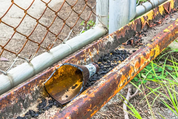 image of broken bottle near the road .