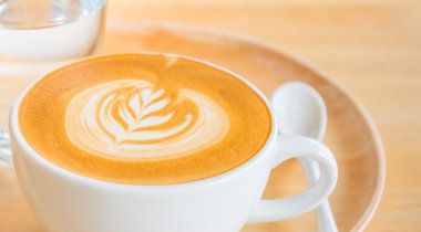 ahşap masa üzerinde bir latte kahve sanat.