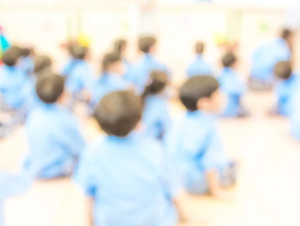 教師と制服姿で子供たちの教室をぼかし — ストック写真