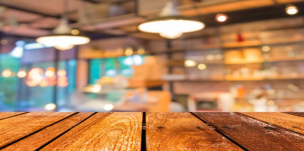 Lege houten tafel en coffeeshop wazig achtergrond met bokeh imag — Stockfoto