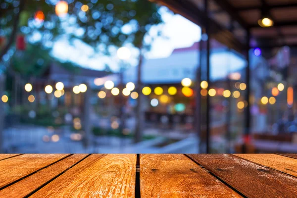 Mesa de madeira vazia e café desfoque fundo com imagem bokeh — Fotografia de Stock