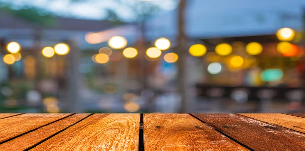 Mesa de madeira vazia e café desfoque fundo com imagem bokeh — Fotografia de Stock