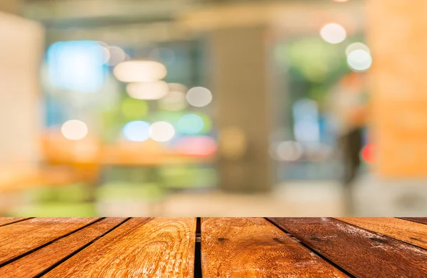 Lege houten tafel en coffeeshop wazig achtergrond met bokeh imag — Stockfoto