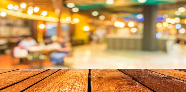 Lege houten tafel en coffeeshop wazig achtergrond met bokeh imag — Stockfoto