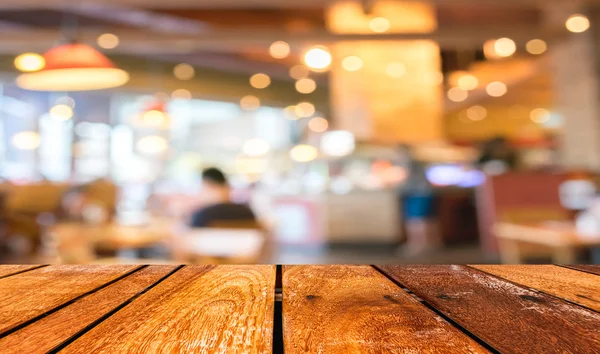 Boş ahşap masa ve kafeterya bokeh IMAG ile arka plan bulanıklık — Stok fotoğraf