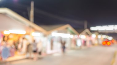 Şenlik ışıklarıyla süslenmiş caddedeki bulanık arka plan gece pazarının görüntüsü.