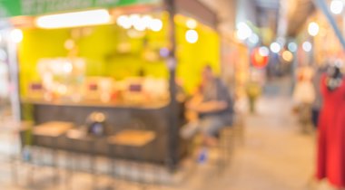 Şenlik ışıklarıyla süslenmiş caddedeki bulanık arka plan gece pazarının görüntüsü.