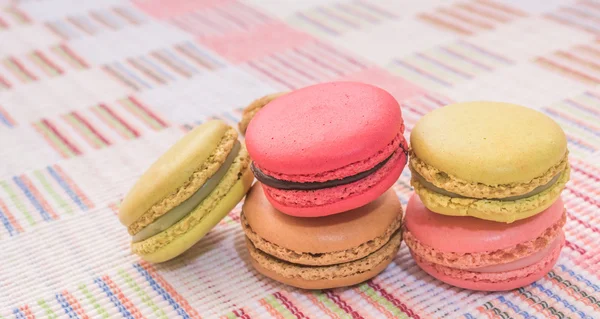 Macarrones franceses dulces y coloridos sobre fondo de tela de algodón . —  Fotos de Stock