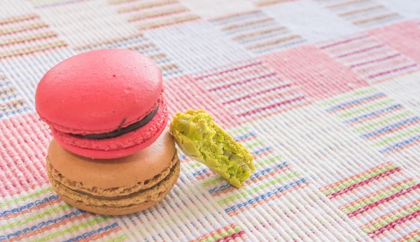 Macarrones franceses dulces y coloridos sobre fondo de tela de algodón . — Foto de Stock
