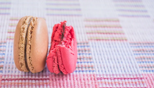 Süße und bunte französische Makronen auf Baumwollstoff Hintergrund. — Stockfoto