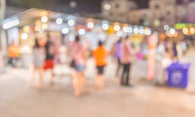 Şenlik ışıklarıyla süslenmiş caddedeki bulanık arka plan gece pazarının görüntüsü.