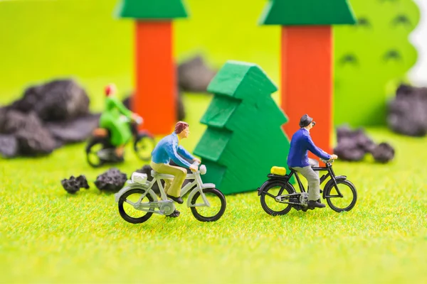 Grupo de imagem de pessoas (mini figura) com bicicleta retro em um parque — Fotografia de Stock