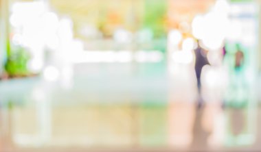 Bulanık bir geçmişi olan modern bir iş merkezinin lobisindeki insanların bulanık görüntüsü..