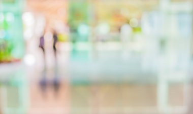 Bulanık bir geçmişi olan modern bir iş merkezinin lobisindeki insanların bulanık görüntüsü..