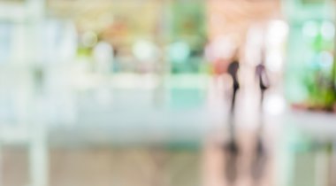 Bulanık bir geçmişi olan modern bir iş merkezinin lobisindeki insanların bulanık görüntüsü..