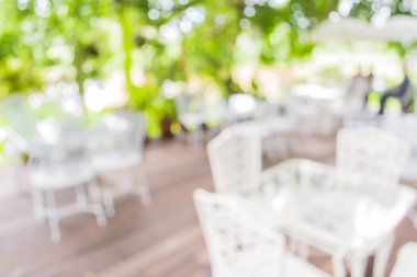 Arka plan kullanımı için yeşil ağaç bokeh ile gündüz vakti bulanık bir restoran görüntüsü .