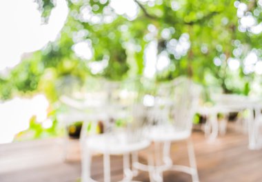 Arka plan kullanımı için yeşil ağaç bokeh ile gündüz vakti bulanık bir restoran görüntüsü .