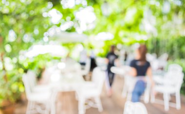 Arka plan kullanımı için yeşil ağaç bokeh ile gündüz vakti bulanık bir restoran görüntüsü .